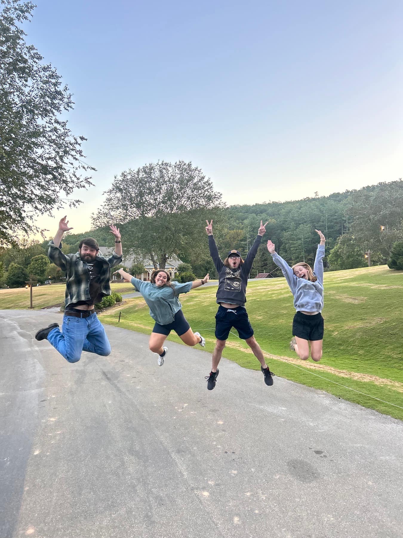 Four RUF students jumping together outside at Fall Conference