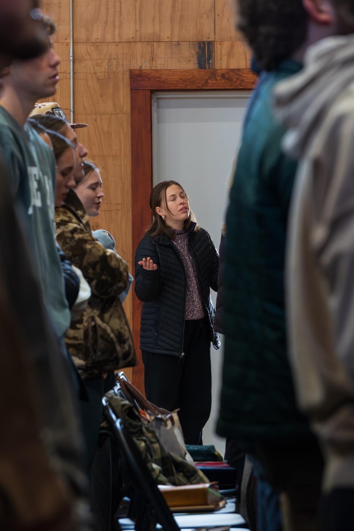 A student participating in a prayer and worship gathering at Winter Retreat
