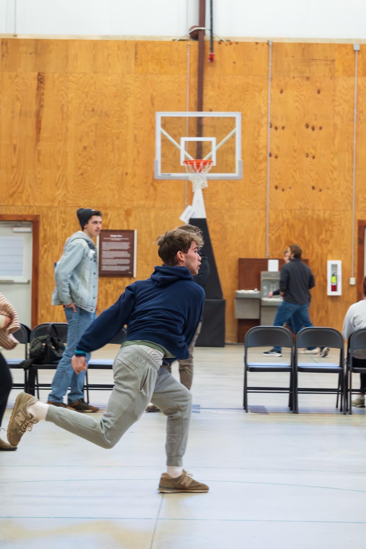 A student running during an indoor Winter Retreat game