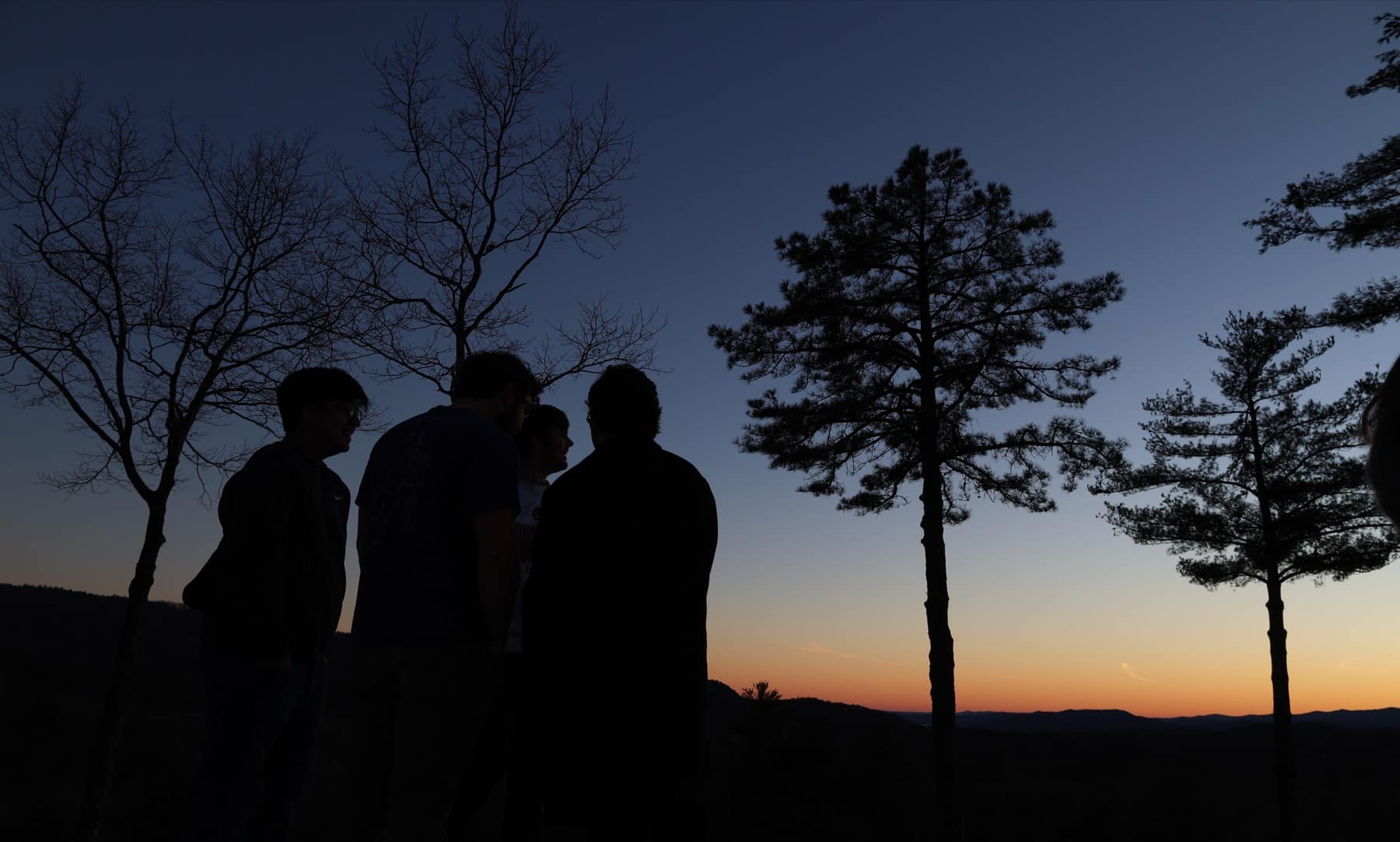 Students silhouetted against the mountain sunset at Winter Retreat