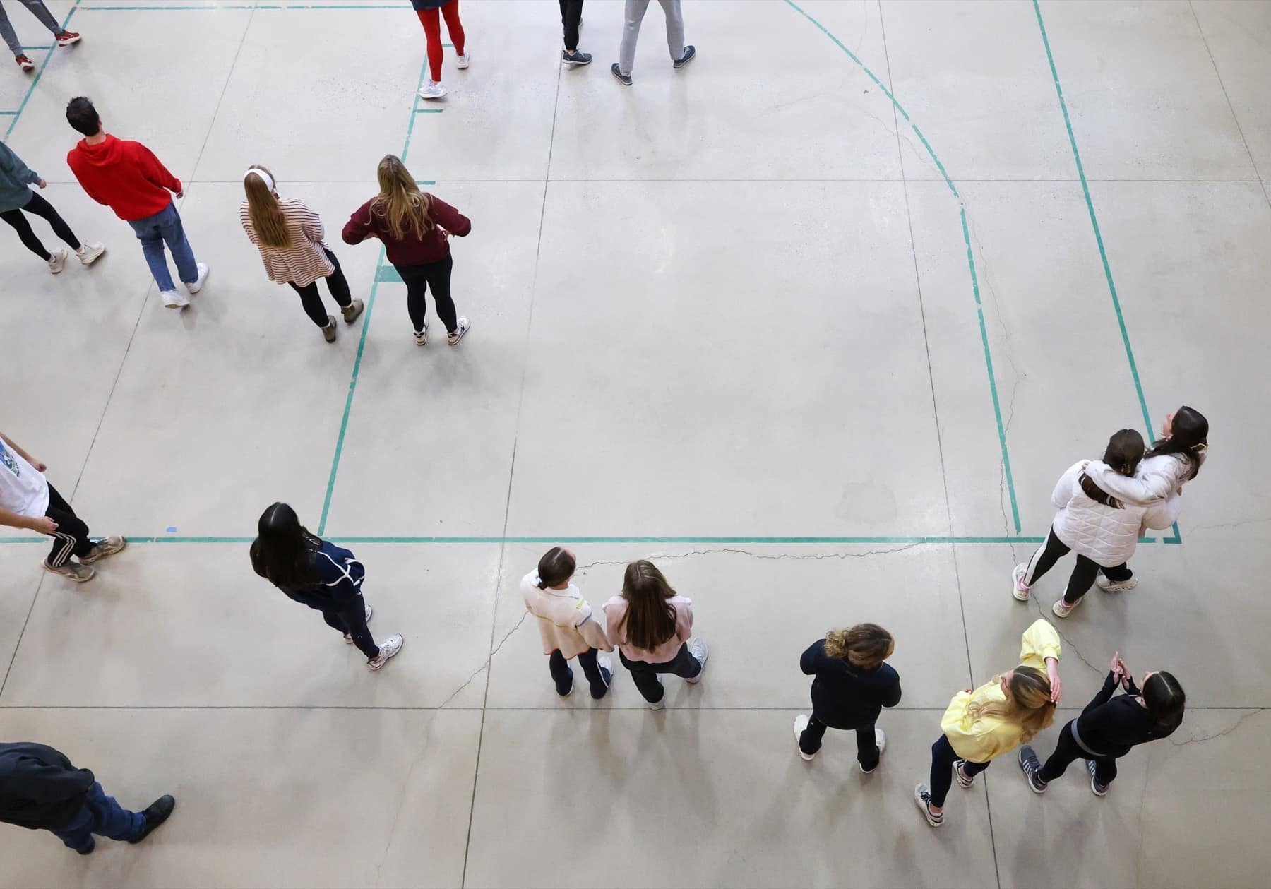 An overhead view of students gathered for games in the Winter Retreat gym