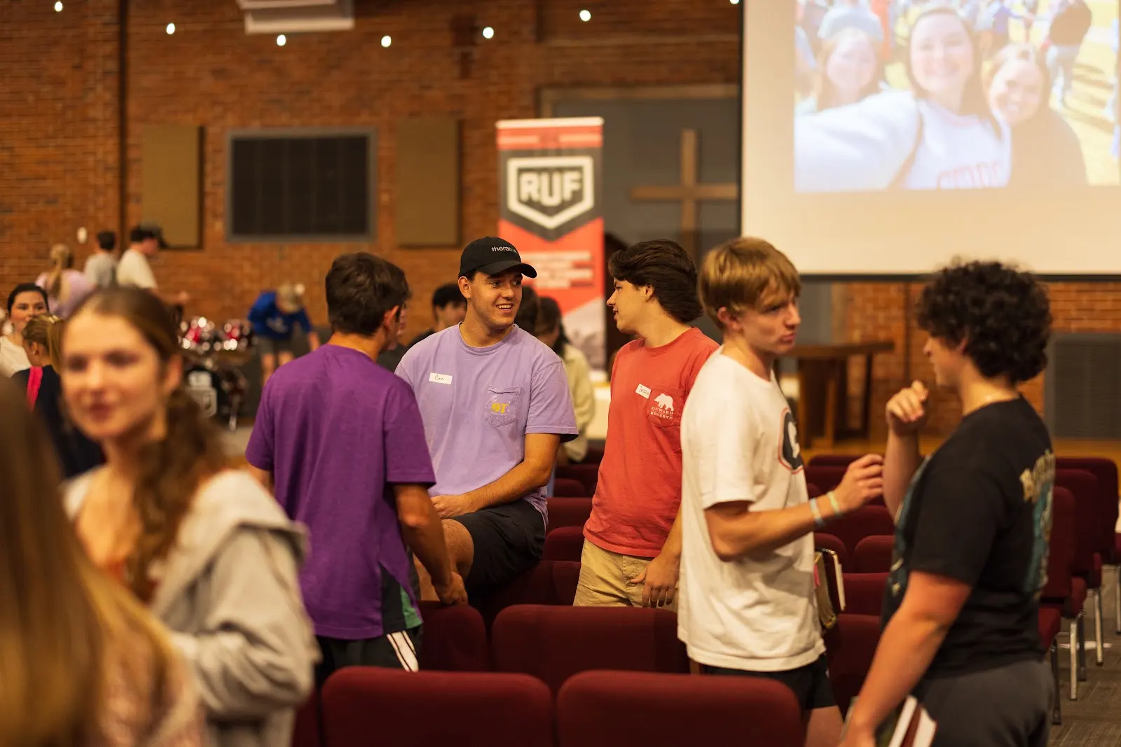 Students arriving and talking together in the Large Group room