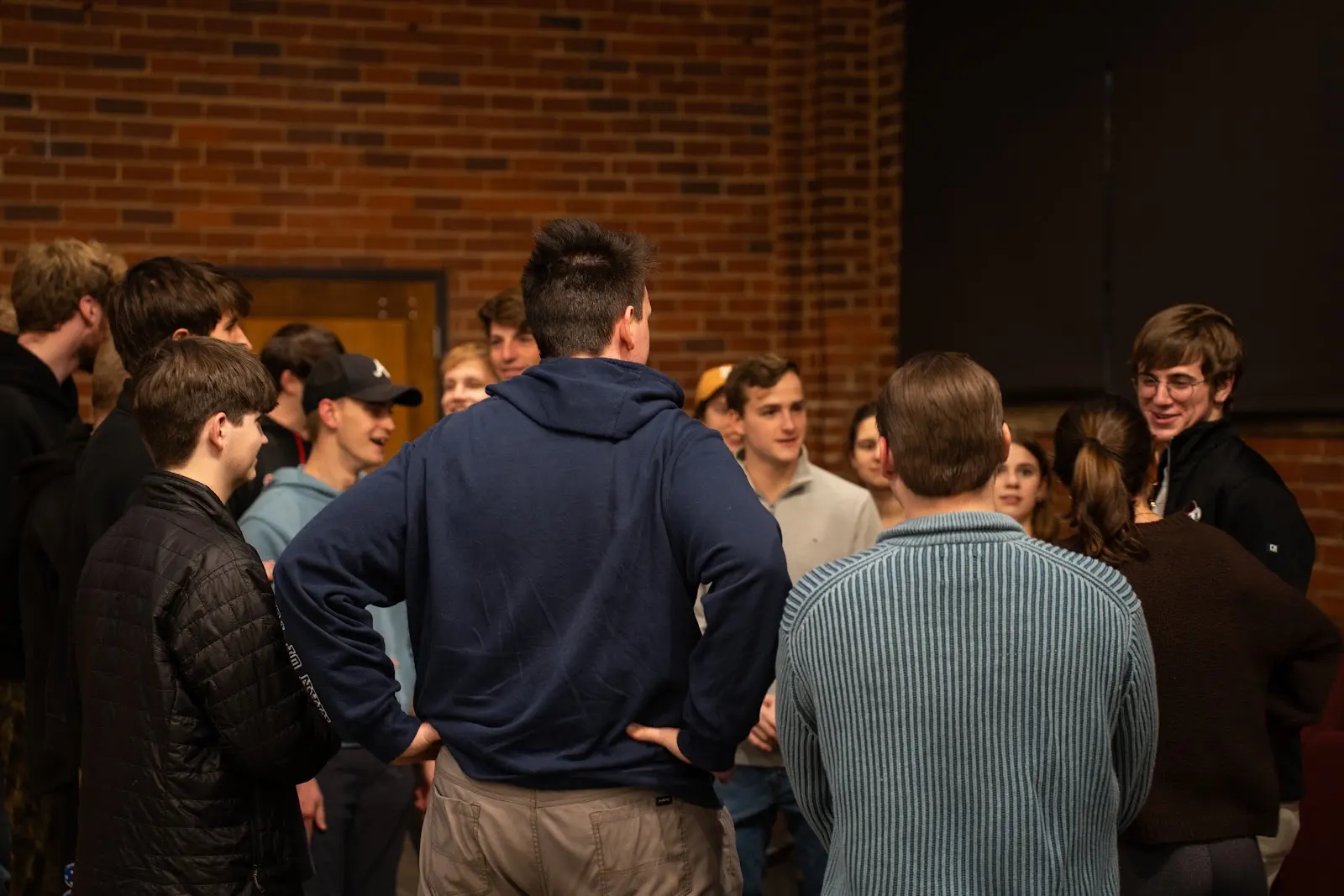A circle of students catching up together before Large Group