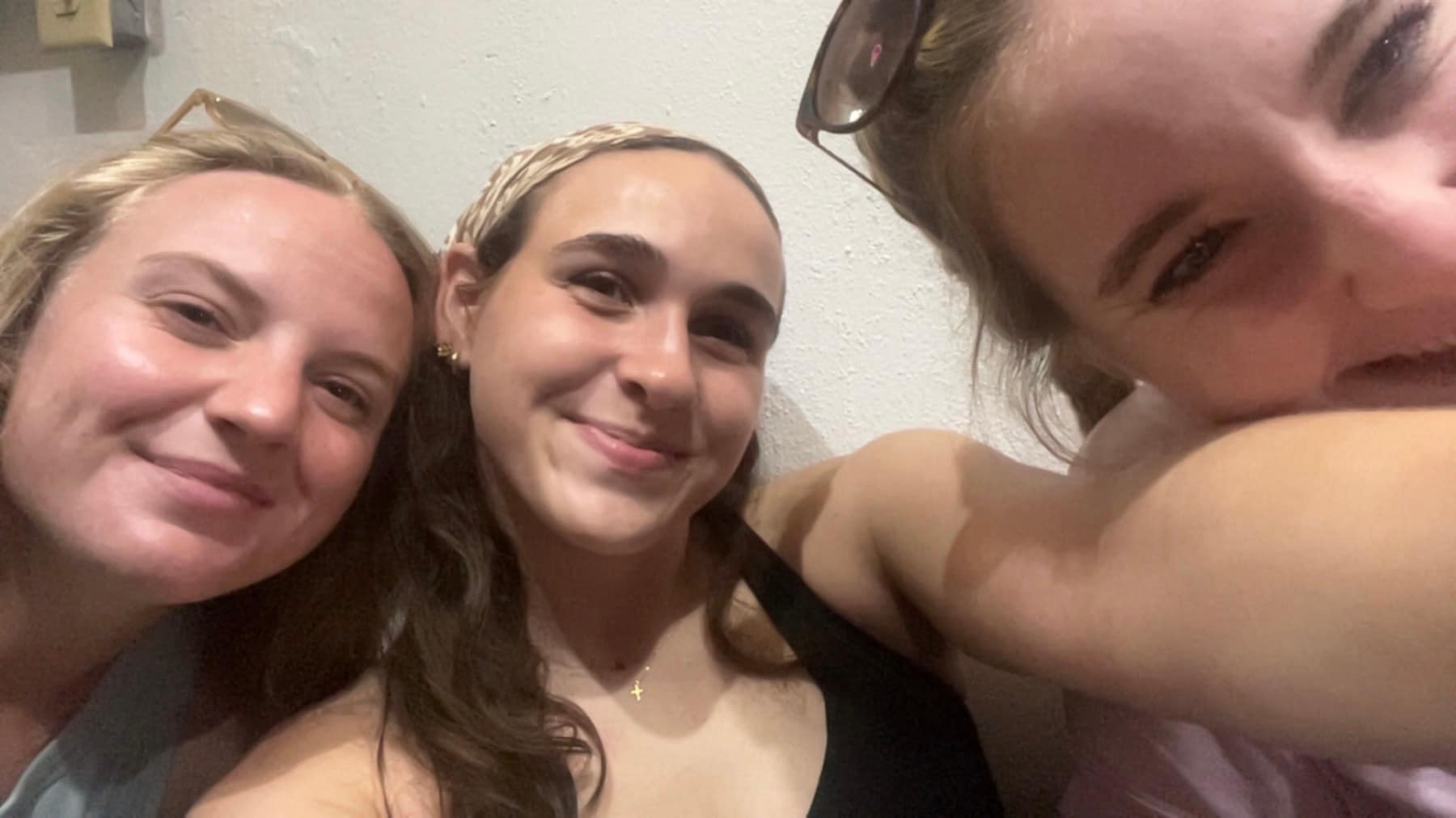Three friends taking a playful selfie during the trip
