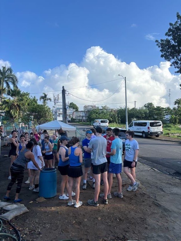 The Puerto Rico mission team gathered together beside the road