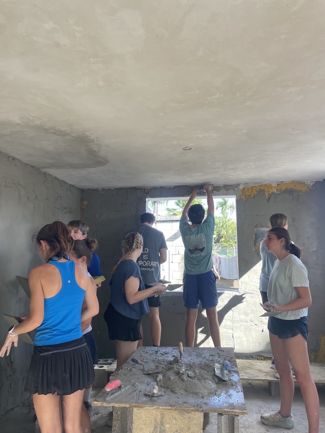 Students painting together inside the community building