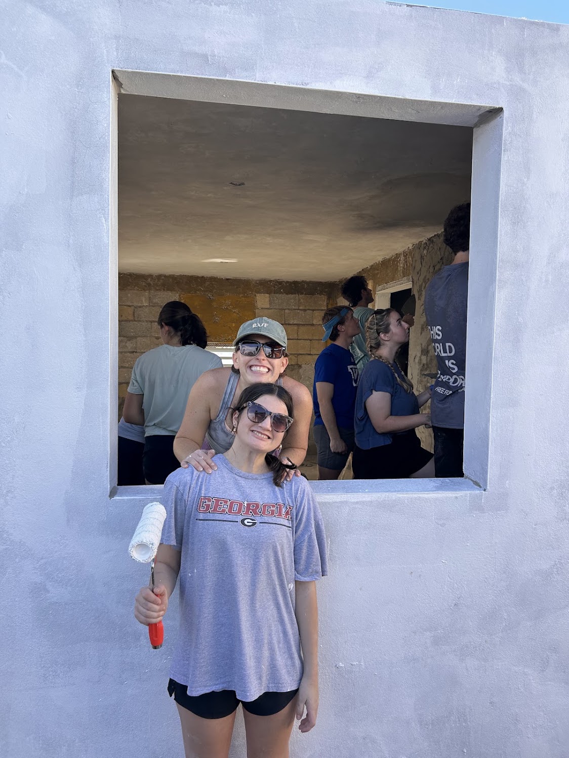 Friends smiling together through a window at the service site