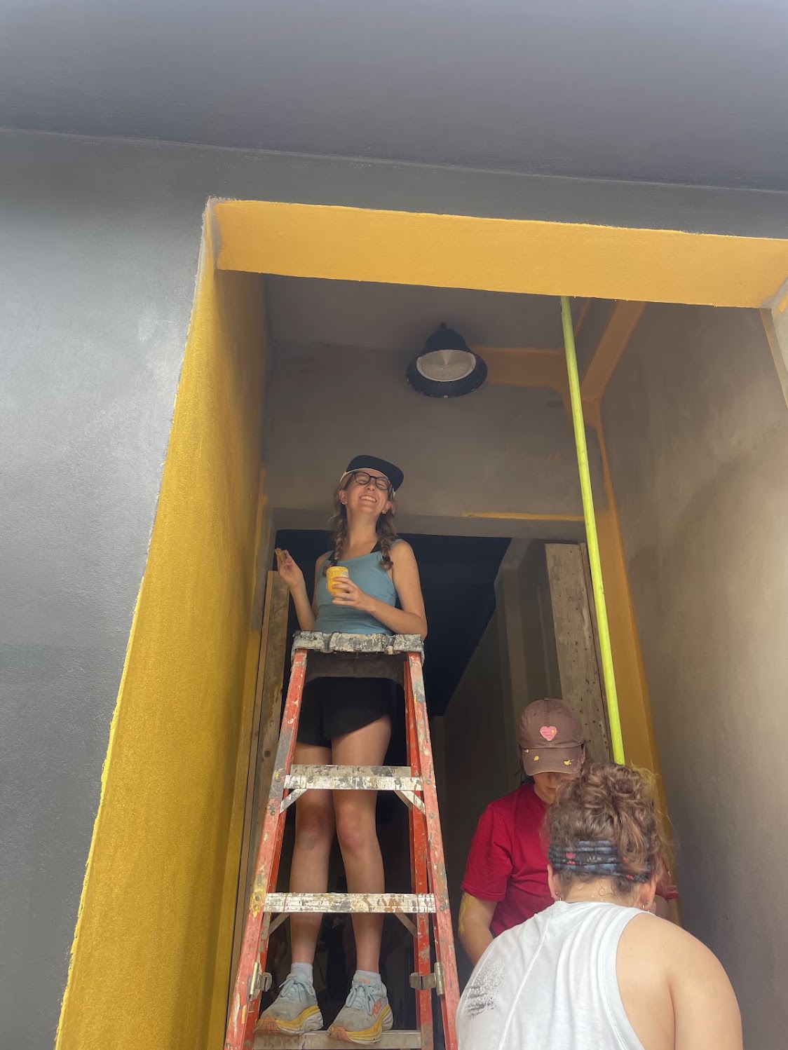 A student painting a doorway during the service project