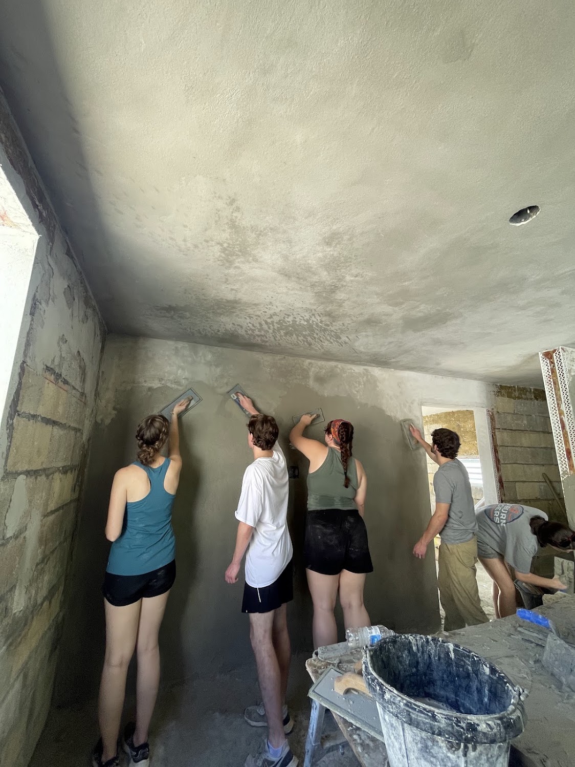 Teammates painting an interior wall together